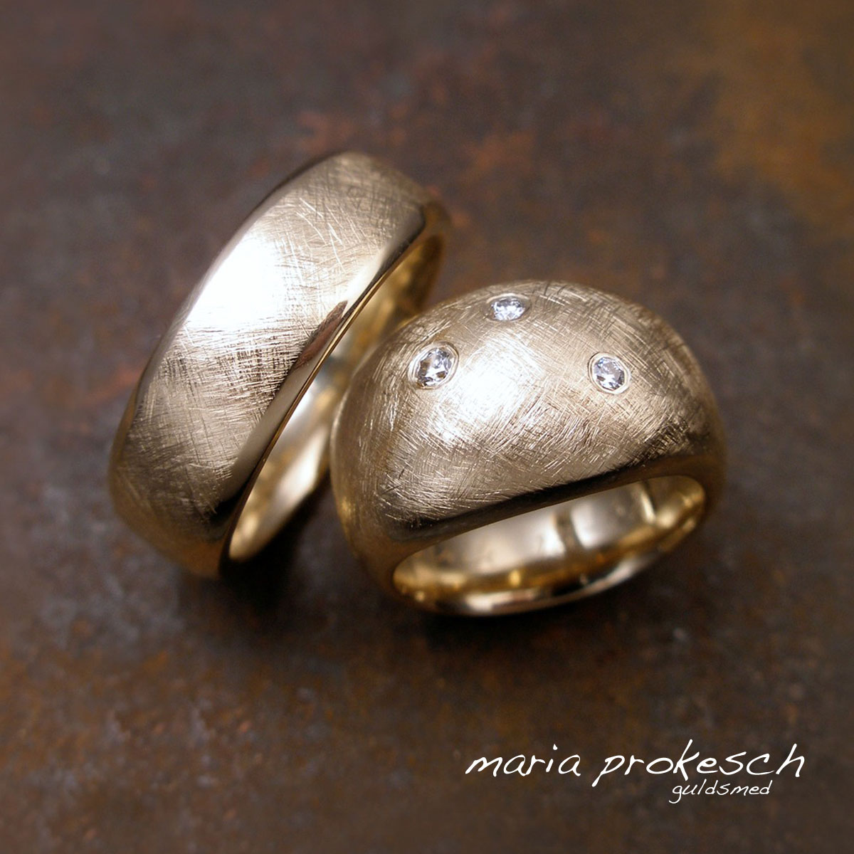Vielsesringe i guld med matteret rustikke og blanke skrå flader. Hendes ring er feminin med buttet anderledes design. Håndlavet fra guldsmeden.