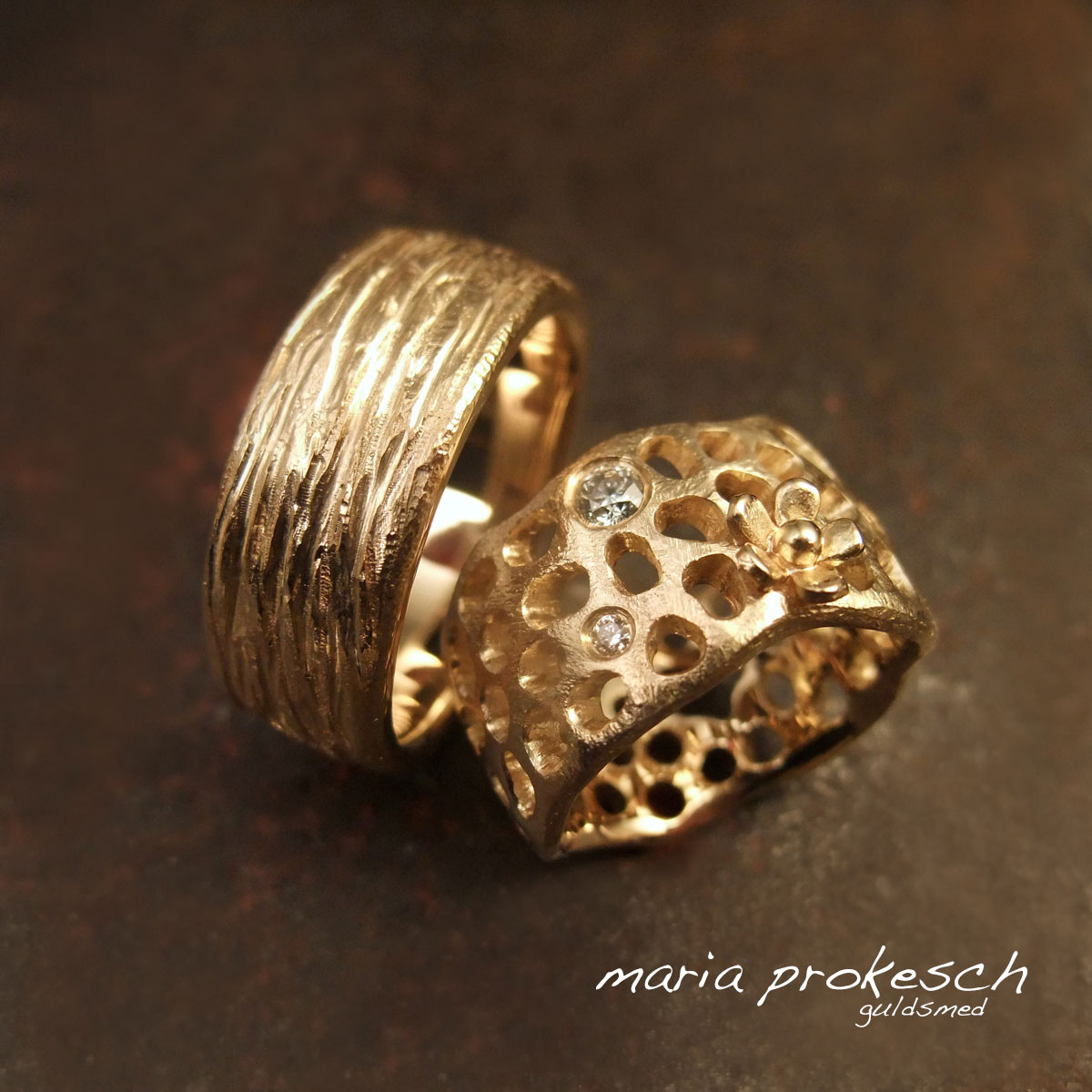 Vielsesringe i guld med blomster og personlige detaljer som gør hendes hulmønster feminin og hans ring maskulin med rustik natur bark overflade.