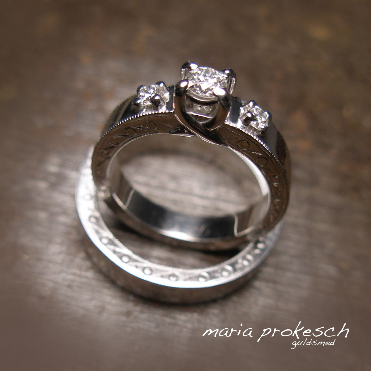Retro design, håndlavede forlovelsesringe hvidguld 14 karat med mange detaljer. Ringe har repercé gravering på sider af ring. Damering med tre sten, hvide diamanter, i grabbe fatninger.