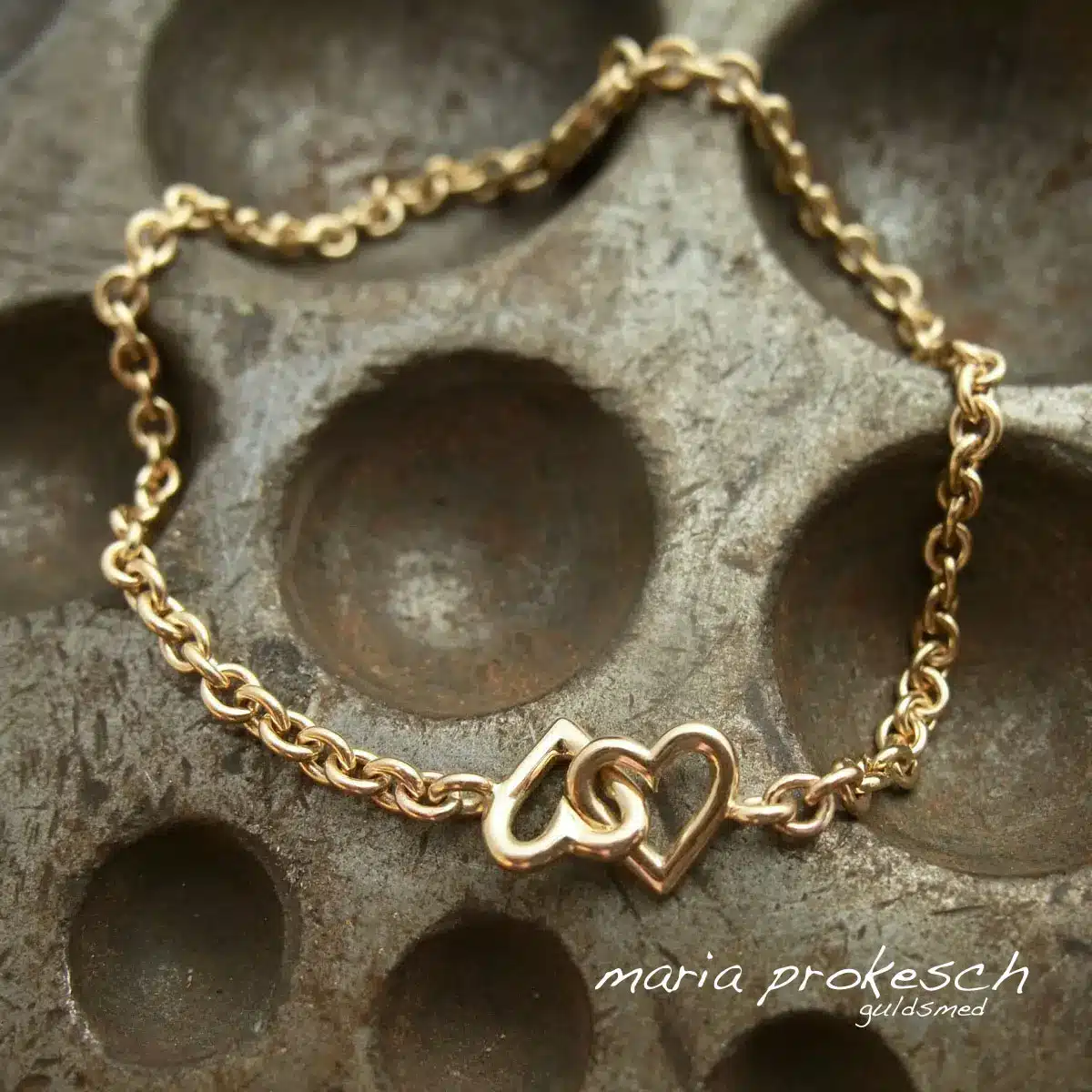 Armbånd i 14 karat guld med to håndlavede hjerter. Enkelt og tidløst design fra guldsmedens værksted. Perfekt som morgengave