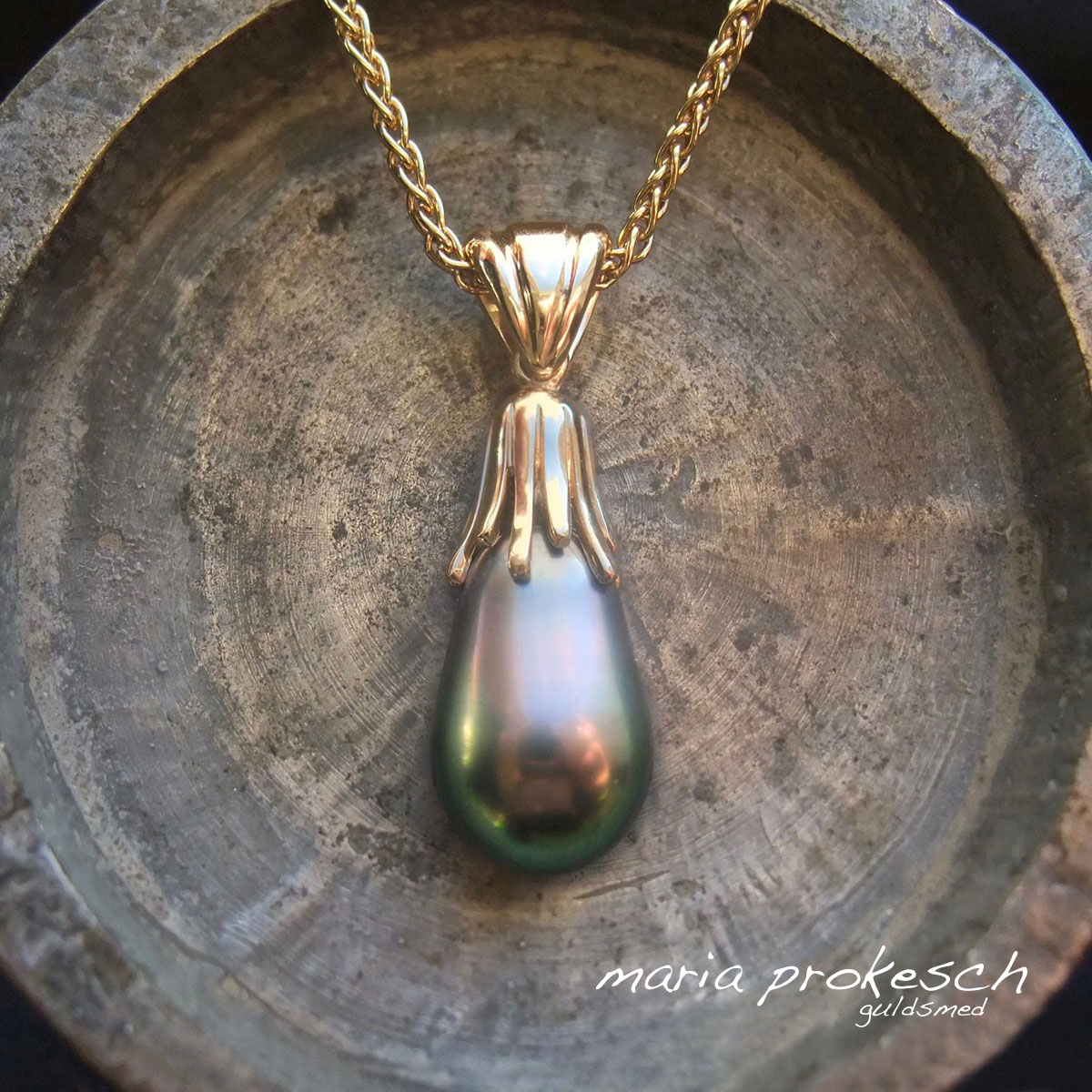 Perle vedhæng i 18 karat guld med auberginefarvet Tahiti perle i halskæde. Et anderledes og utraditionel design med guldpynt og patz øsken