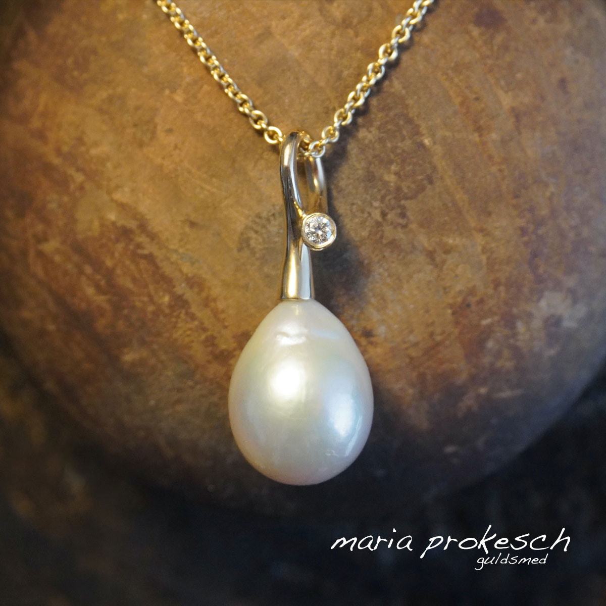 Vedhæng med stor hvid dråbeformet ferskvands perle. Ophænget i 18 karat guld i elegant design med fin detalje hvor diamanten sidder.