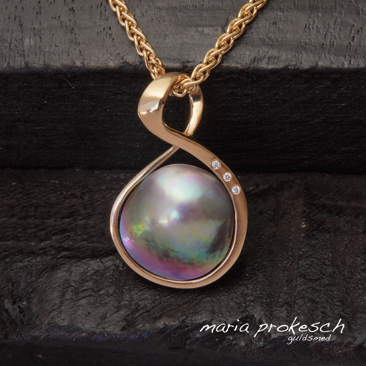 Cortez mabe perle i flotte farver, et enkelt 18 karat guldvedhæng. Et anderledes design med elegant guldindfatning og sten, små hvide diamanter (brillanter)